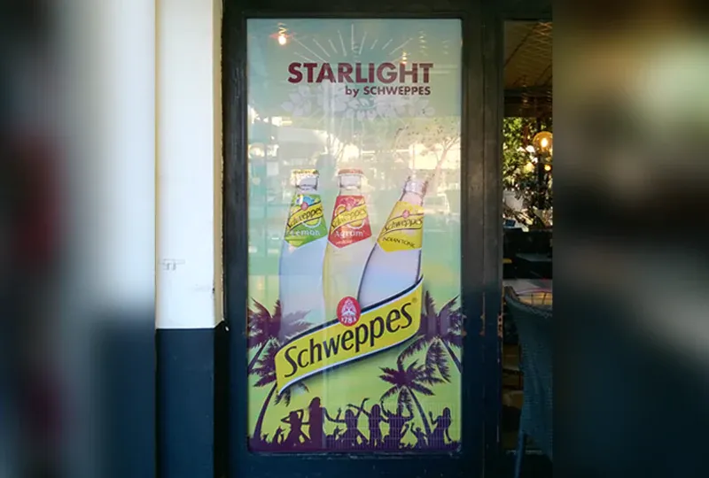 Impression Schweppes sur film transparent en vitrophanie pour une brasserie restaurant